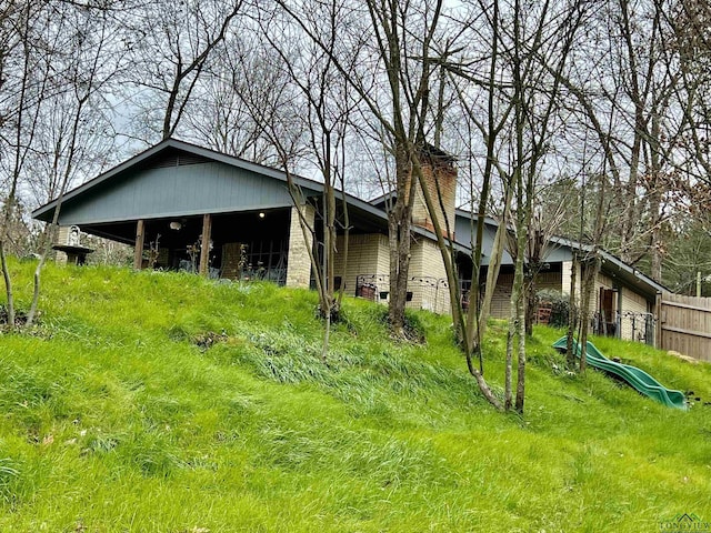 exterior space featuring a chimney and fence