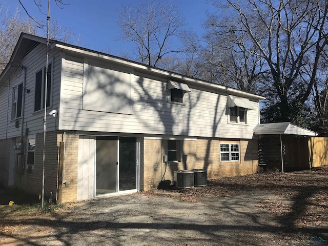 back of property with a carport and central air condition unit