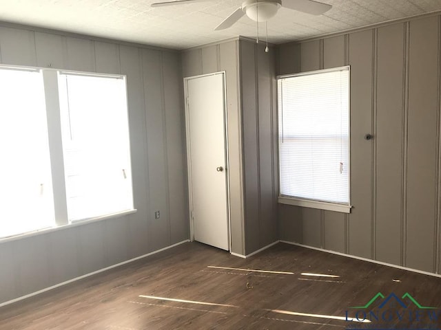 unfurnished bedroom with dark wood-type flooring and ceiling fan