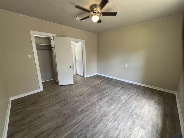 714 W Quitman Ave, Gladewater, TX 75647 - unfurnished bedroom featuring dark wood-type flooring, crown molding, baseboards, ceiling fan, and a closet