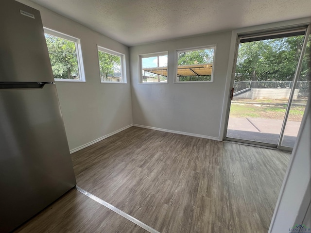 714 W Quitman Ave, Gladewater, TX 75647 - spare room featuring wood finished floors, a textured ceiling, and baseboards