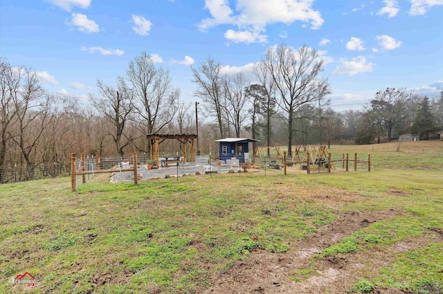 view of yard with an outbuilding, a rural view, and fence