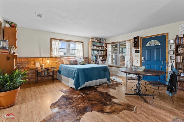 bedroom featuring light wood-type flooring, access to outside, and visible vents