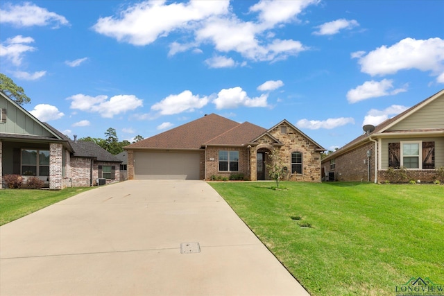 view of front of property featuring brick siding, an attached garage, driveway, and a front yard