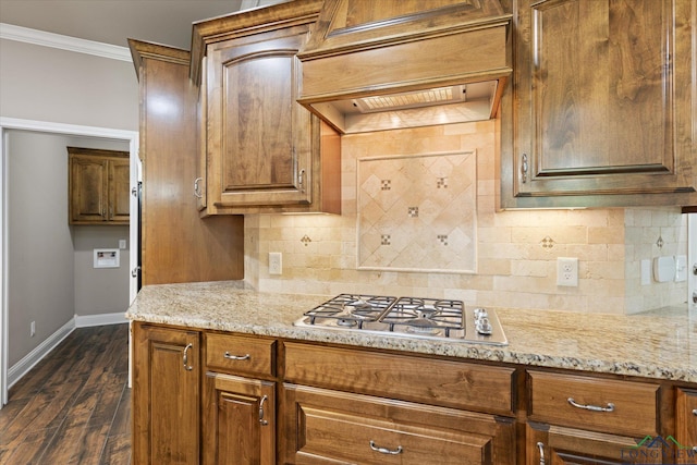 3363 Celebration Way, Longview, TX 75605 - kitchen with stainless steel gas stovetop, crown molding, tasteful backsplash, custom range hood, and dark wood-type flooring