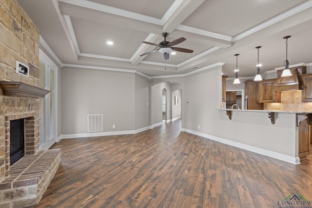 3363 Celebration Way, Longview, TX 75605 - unfurnished living room featuring a ceiling fan, dark wood-type flooring, ornamental molding, a fireplace, and beam ceiling