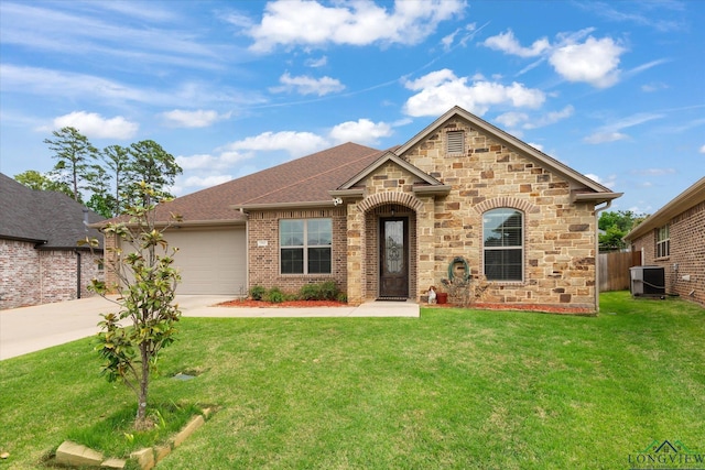 view of front of property with stone siding, a garage, a front yard, central AC unit, and concrete driveway