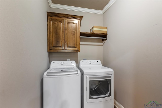 clothes washing area featuring separate washer and dryer, cabinet space, and crown molding
