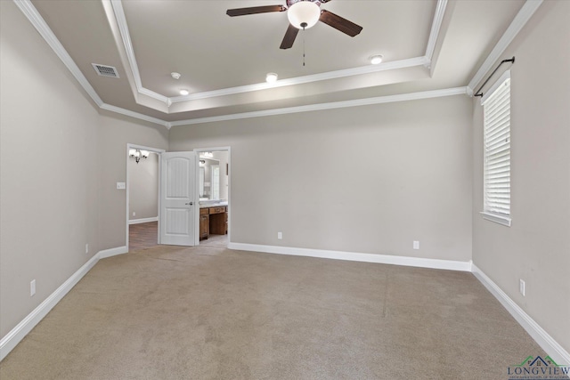 3363 Celebration Way, Longview, TX 75605 - unfurnished bedroom with a tray ceiling, ornamental molding, light carpet, and ensuite bath