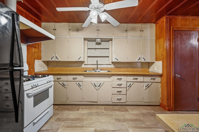 kitchen featuring black refrigerator, wooden ceiling, sink, and white range with gas cooktop