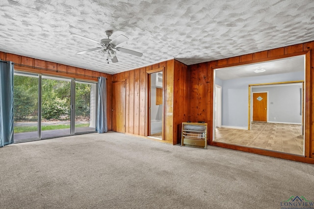 interior space featuring carpet floors, heating unit, and wooden walls