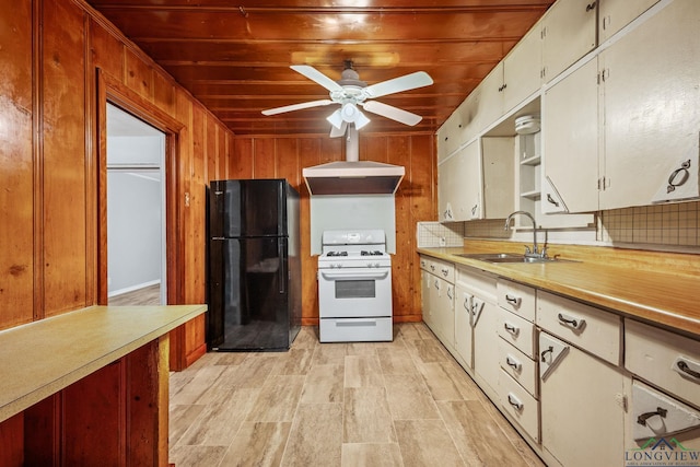 kitchen with black fridge, wall chimney exhaust hood, white range, sink, and wooden ceiling