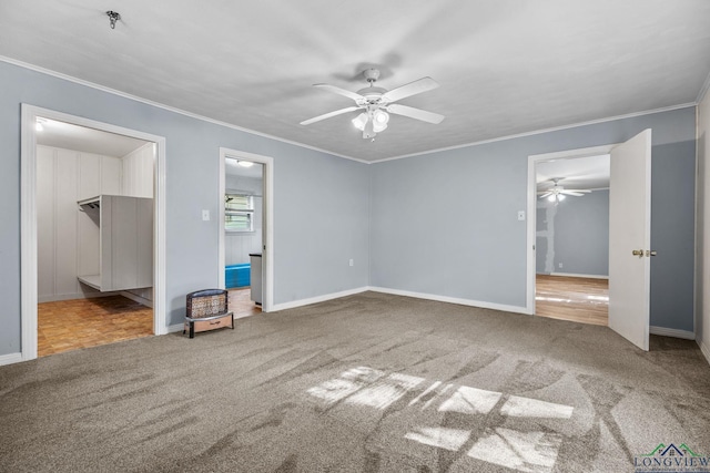 unfurnished bedroom featuring carpet flooring, a walk in closet, ceiling fan, and ornamental molding