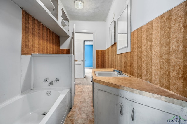 bathroom featuring a bathing tub, wooden walls, vanity, and a textured ceiling