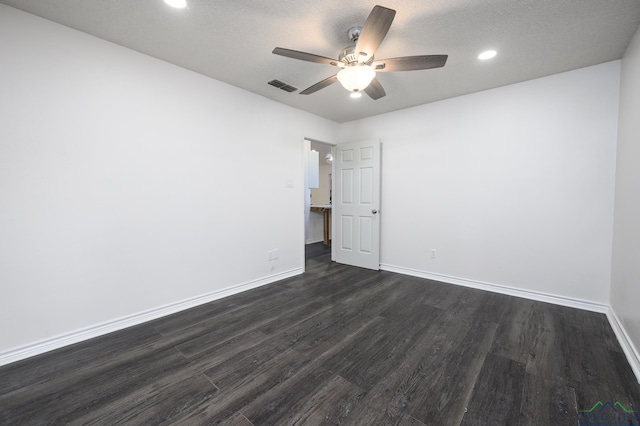 spare room with baseboards, visible vents, ceiling fan, and dark wood-type flooring