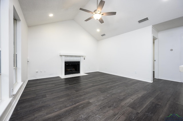 unfurnished living room with dark wood-style floors, lofted ceiling, visible vents, a fireplace with flush hearth, and a ceiling fan