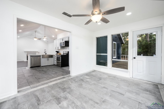 kitchen featuring lofted ceiling, stainless steel appliances, a sink, visible vents, and open floor plan