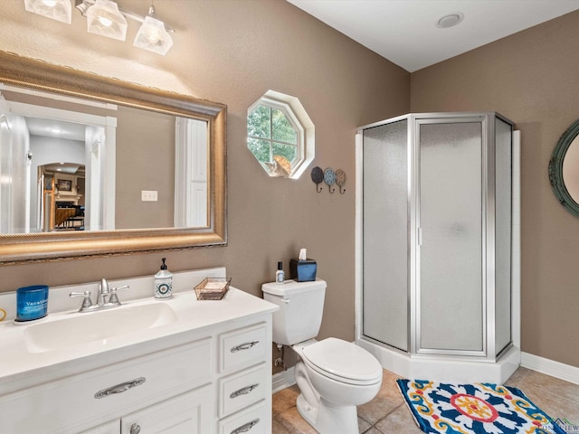 bathroom with tile patterned flooring, vanity, toilet, and a shower with door