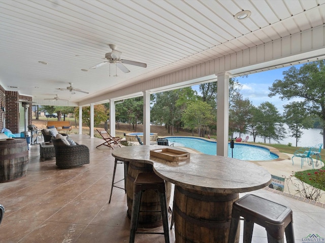 sunroom / solarium featuring ceiling fan and a pool