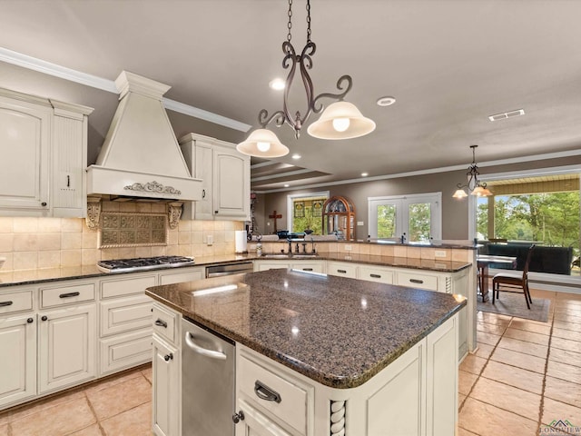 kitchen with kitchen peninsula, a center island, hanging light fixtures, and custom exhaust hood