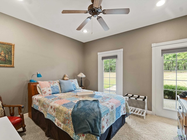 bedroom featuring multiple windows, light colored carpet, and ceiling fan