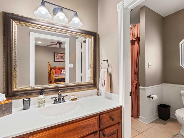 bathroom with tile patterned floors, vanity, toilet, and ceiling fan