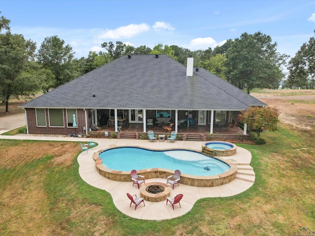 view of pool with an in ground hot tub, an outdoor fire pit, a patio area, and a lawn