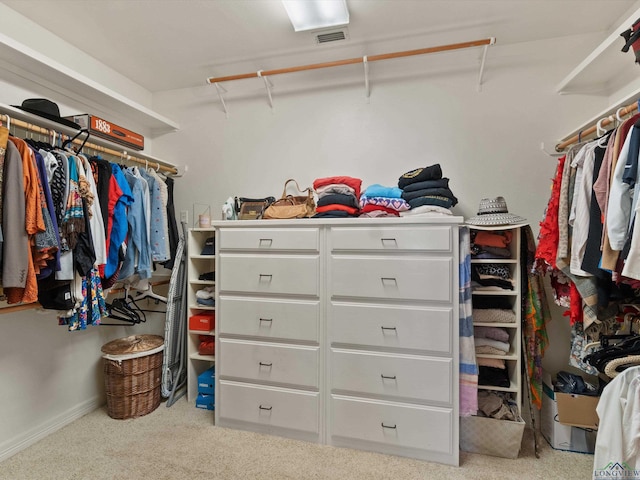 walk in closet with light carpet