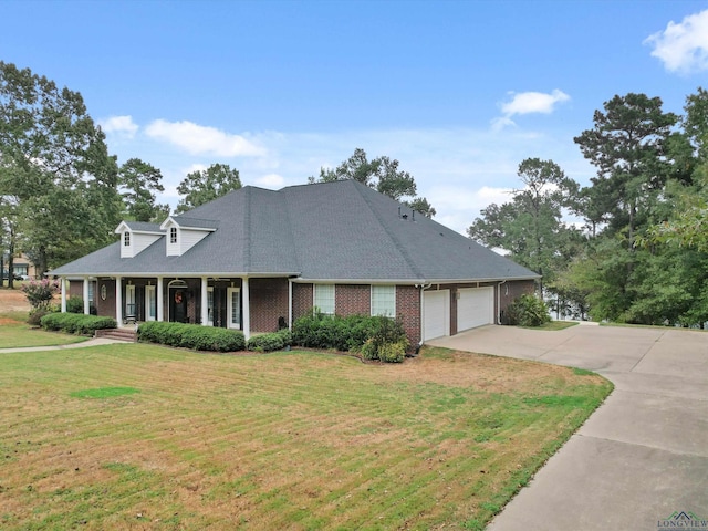 view of front of home with a front yard, a porch, and a garage