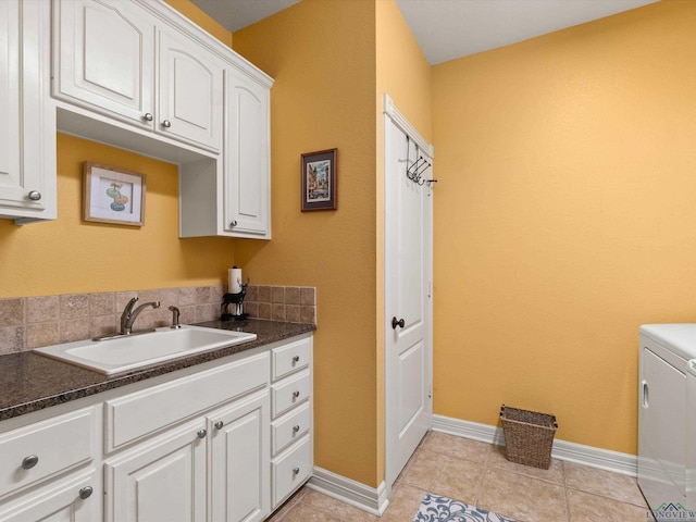 clothes washing area featuring cabinets, washer / dryer, light tile patterned floors, and sink