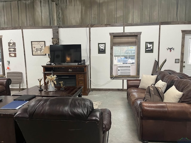 living room with baseboards, cooling unit, and concrete flooring