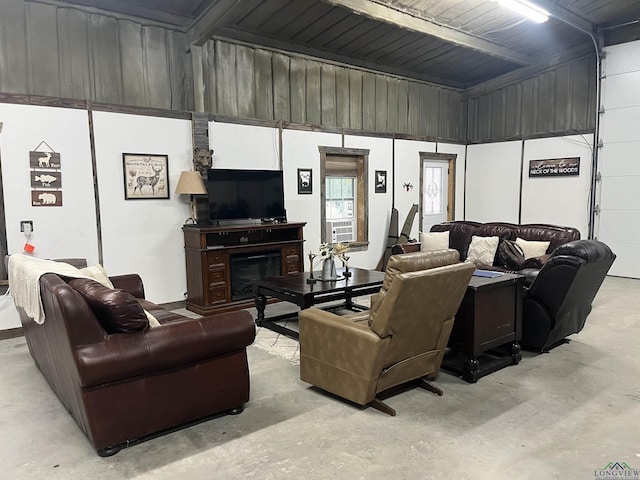 living area with a glass covered fireplace and concrete floors