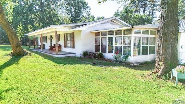 view of front facade with a sunroom and a front yard