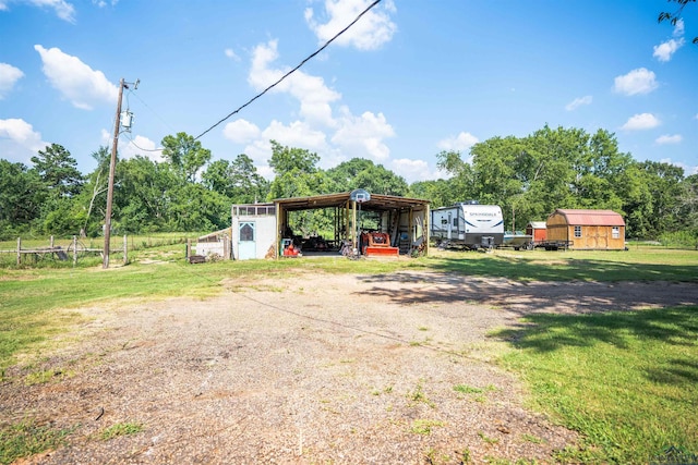 view of front facade featuring a storage shed, a front lawn, and a carport