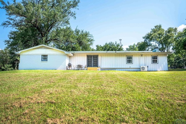 back of property with a yard and ac unit