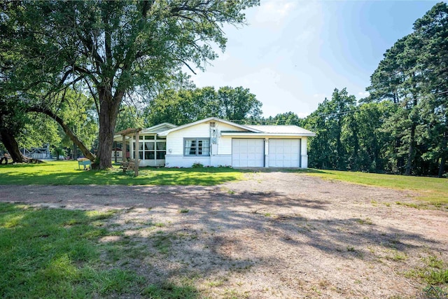 single story home with a garage, a sunroom, and a front lawn