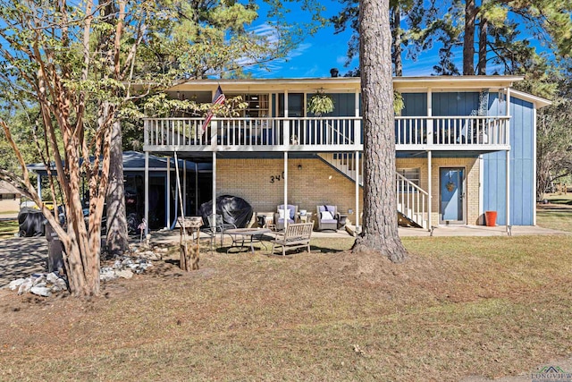 back of property with a patio, a deck, and a lawn