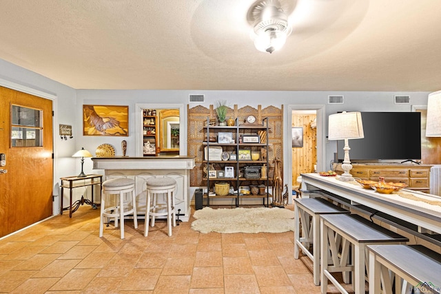 kitchen with a breakfast bar and a textured ceiling