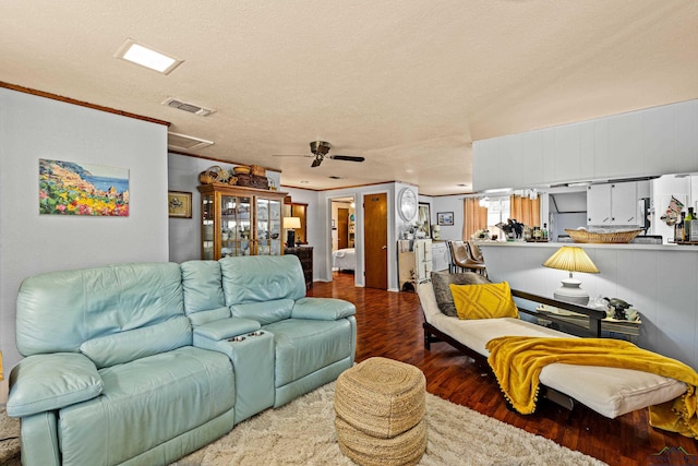 living room with wood-type flooring, a textured ceiling, ceiling fan, and ornamental molding