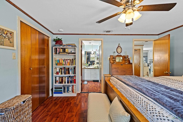 bedroom with ornamental molding, ceiling fan, dark wood-type flooring, connected bathroom, and a closet