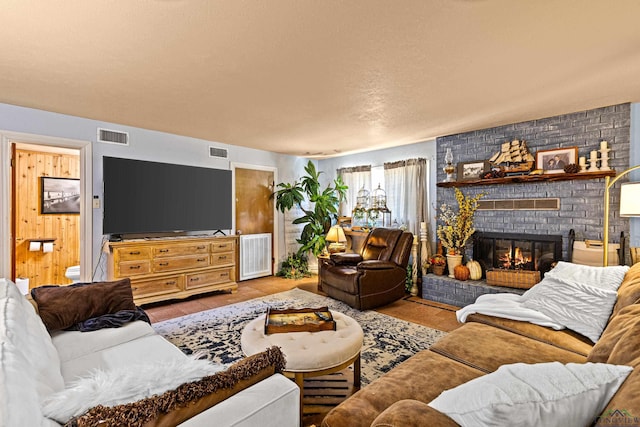 tiled living room with a textured ceiling and a fireplace