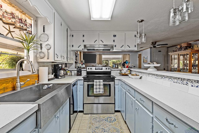 kitchen with ceiling fan, sink, pendant lighting, stainless steel electric stove, and light tile patterned floors