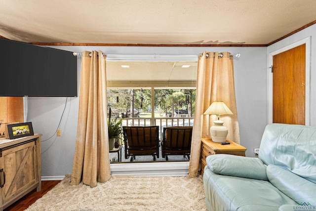 sitting room featuring crown molding, wood-type flooring, and a textured ceiling