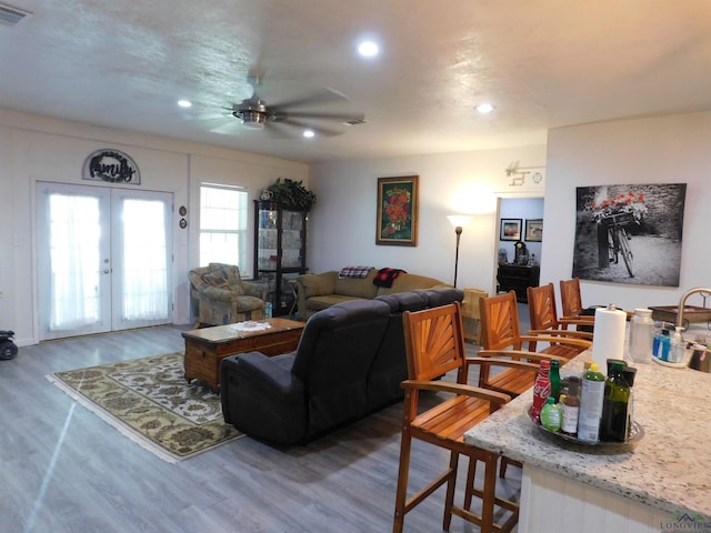 living room featuring ceiling fan, wood-type flooring, and french doors