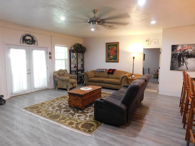 living room with french doors, light wood-type flooring, and ceiling fan