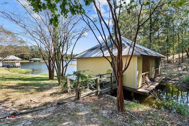 view of home's exterior with a gazebo and a water view