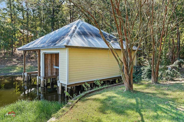 view of home's exterior featuring a yard, a dock, and a water view