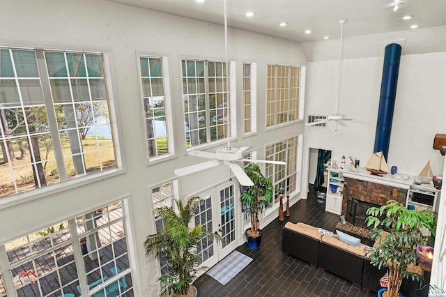 interior space featuring a fireplace, french doors, and ceiling fan