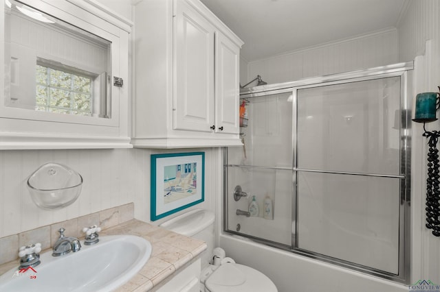 full bathroom featuring toilet, vanity, and shower / bath combination with glass door