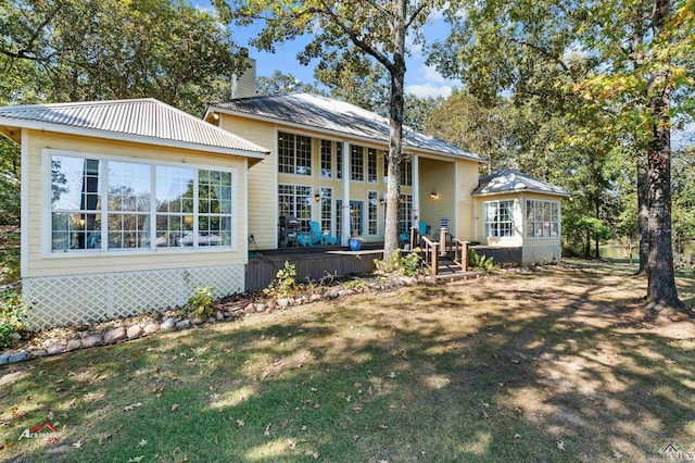 rear view of property with a wooden deck and a lawn